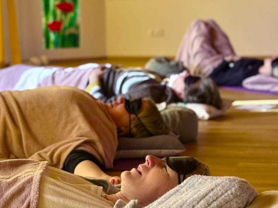 Entspannte Frauen liegen während eines Breathwork-Workshops in Linz auf Matten und folgen Atemübungen
